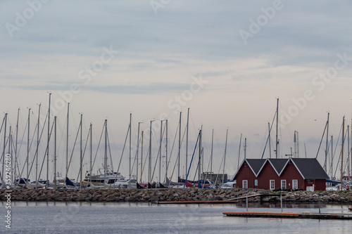Obraz na płótnie Sailboats marina with small dark red houses in fisherman's village. w salonie
