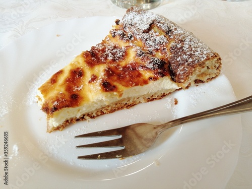Traditional Slovenian cheese cake, piece on plate with fork, close up