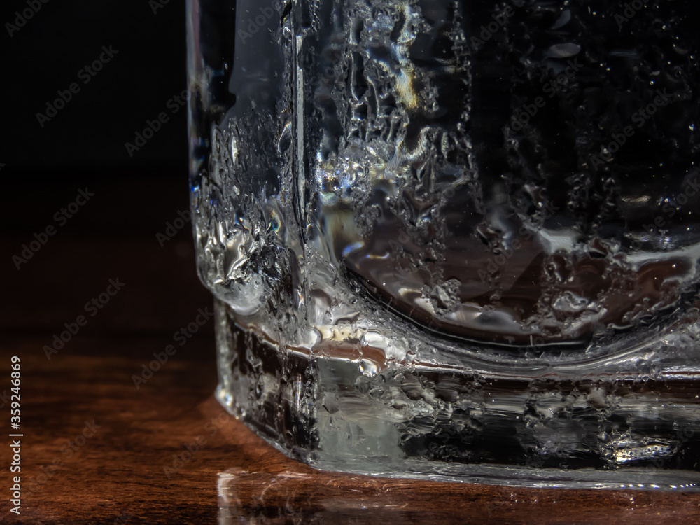 Close up of ice cubes floating on the cold water in the glass.