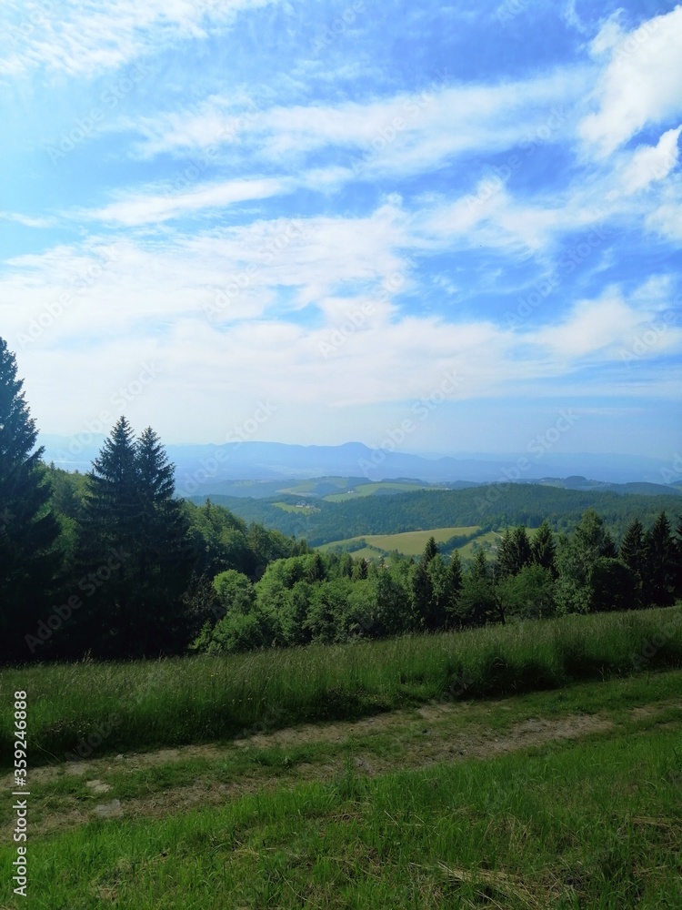 Panoramic view over slovenian hill landscape, sky with clouds, summer