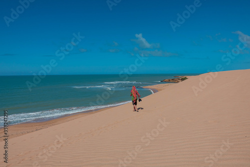 The dunes of Taroa |Man walks over the sand to the beach - Tourism |Punta Gallinas Colombia Travel photo