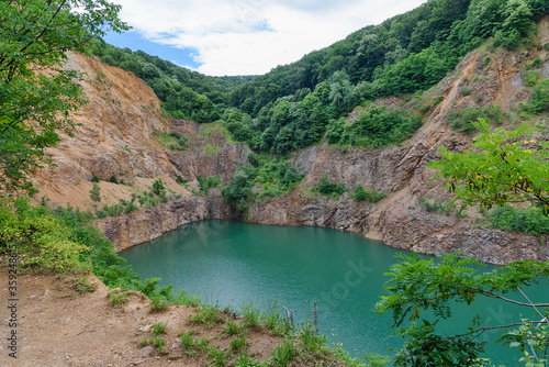 Beautiful Lake Ledinci (serbian: Ledinacko jezero) near Fruska Gora in Serbia, once there was a stone pit. Beautiful vibrant green deep mountain lake, hidden and surrounded by rocks and woods.
