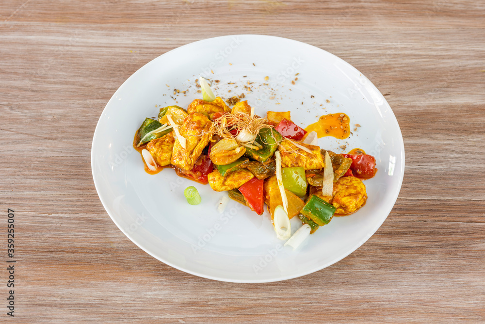 Plate of Murgh Kadhai on wooden background Plate of Murgh Kadhai on wooden background