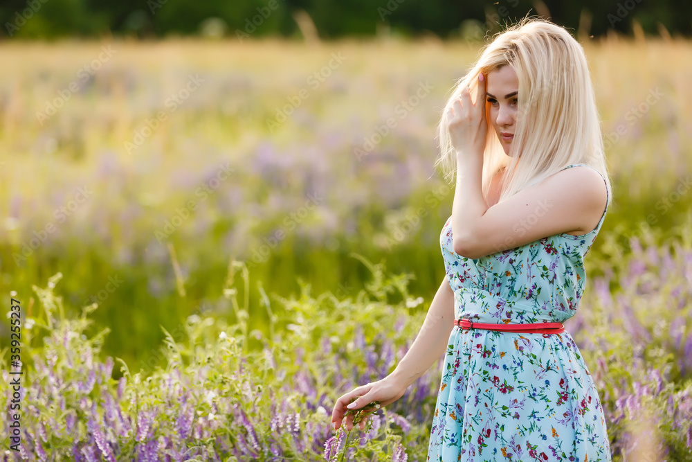 outdoor portrait of a beautiful middle aged blonde woman. attractive sexy girl in a field with flowers outdoor portrait of a beautiful middle aged blonde woman. attractive sexy girl in a field with flowers