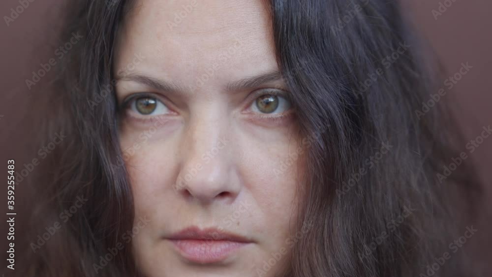 Portrait of beautiful adult woman during conversation close up of brunette woman face, attractive woman thinking, looking at camera, female person with long hair on brown background. Portrait of beautiful adult woman during conversation close up of brunette woman face, attractive woman thinking, looking at camera, female person with long hair on brown background.