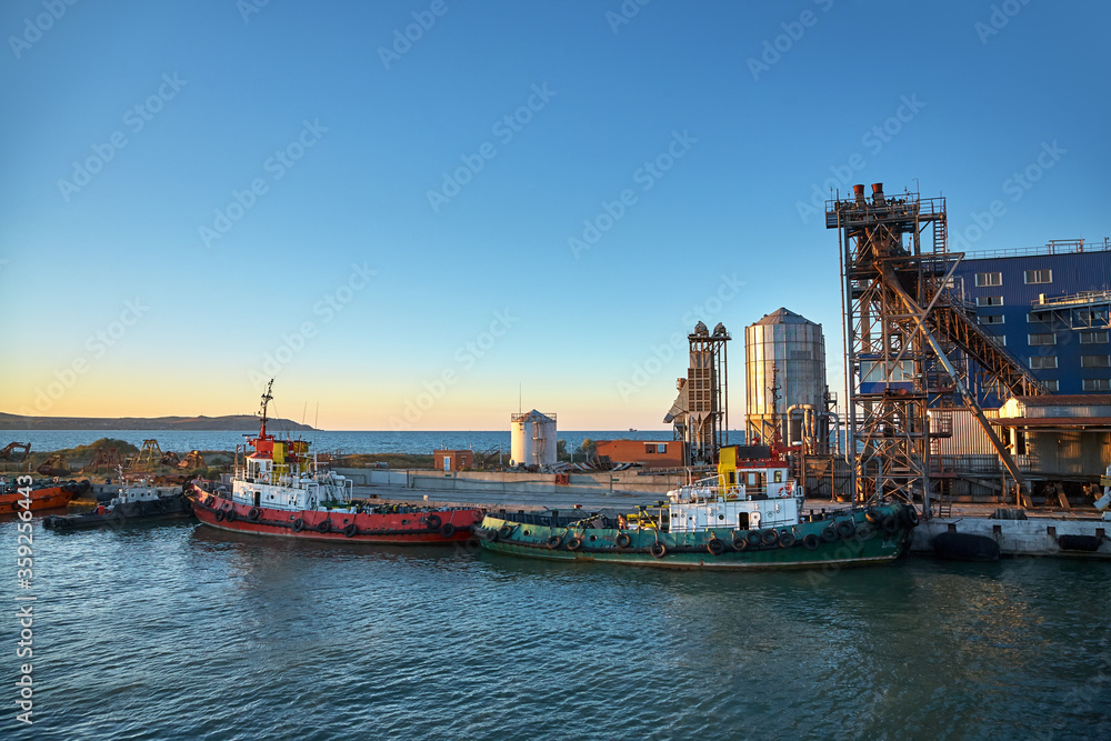 Ships in a cargo seaport at sunset.