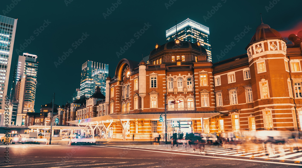 Motion blurred people crossing the intersection in front of Tokyo station at night