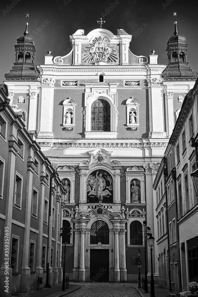 facade of the baroque church decorated with columns and statues in Poznan, black and white.