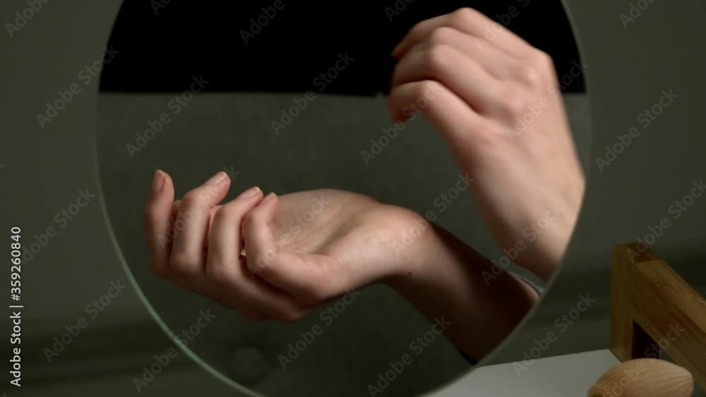 Reflection of female hands with perfume in mirror Reflection of female hands with perfume in mirror