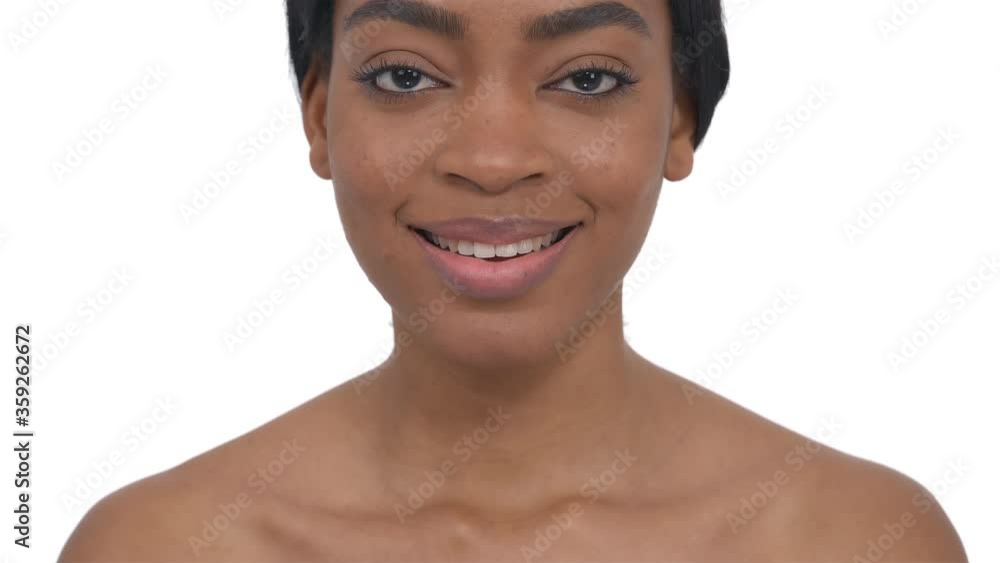 Portrait of a confident black woman raising her head, looking to camera and smiling. Isolated one the white background. Portrait of a confident black woman raising her head, looking to camera and smiling. Isolated one the white background.