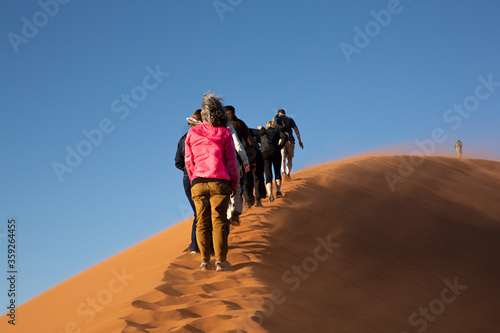 Grupo de personas subiendo a la duna 45 en el desierto de Sossusvlei, Namibia. © Lola Fdez. Nogales
