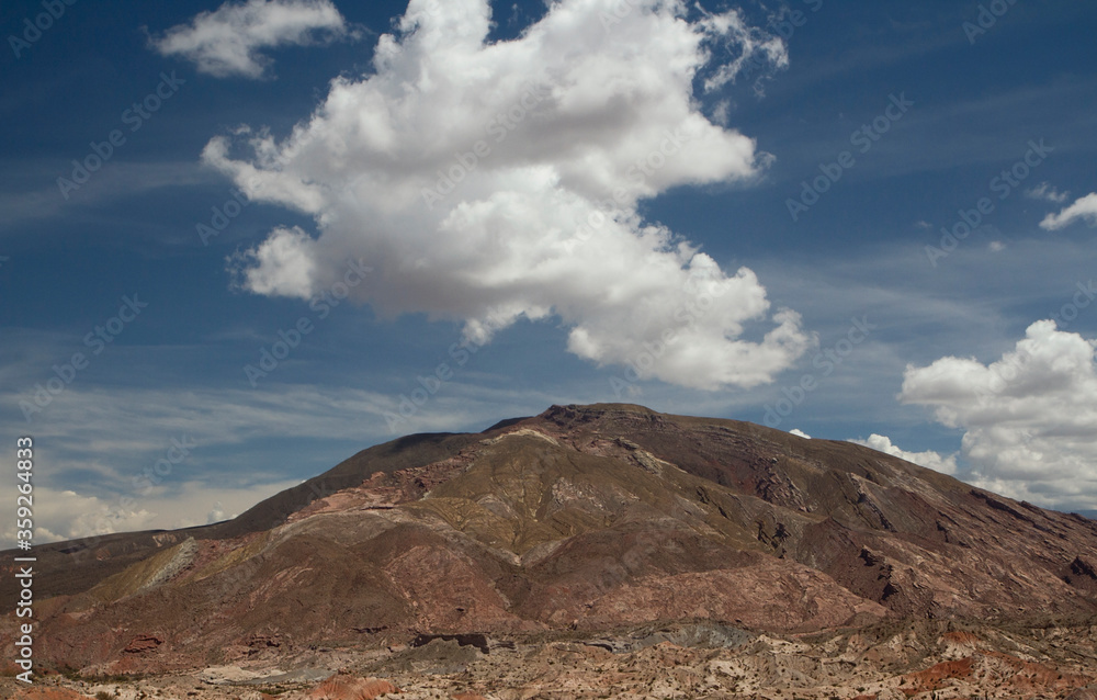Desert landscape. Colorful hill under a beautiful single cloud.