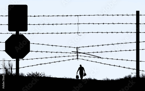A man is seen in silhouette after breaching a border fence on the southern border of the USA. 

