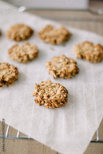 Recipe for homemade oatmeal cookies. Pieces are laid out on parchment paper and a grate.