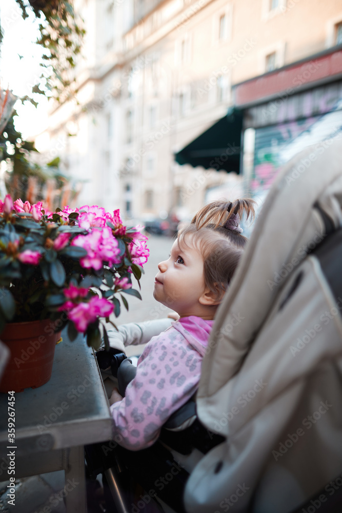 A small child sniffs flowers sitting in a chair