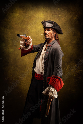 Portrait of a pirate, holding two musket pistol in his hands photo