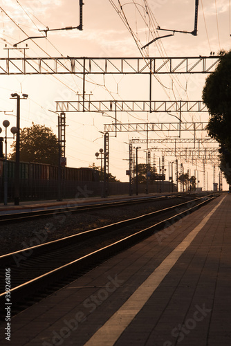 train station at sunset. Rails that go off into the distance. The silhouettes of the pillars.