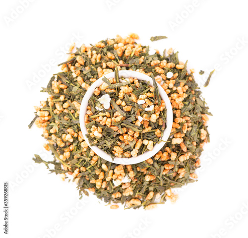 Japanese green tea Genmaicha, isolated on white background. Tea leaves with roasted brown rice. Organic tea. Top view. Close up. photo