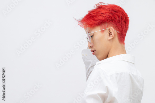 Portrait of a man with bright colored flying hair, all shades of red,purple. Hair coloring.Hair fluttering in the wind. Teenager with short hair. Professional coloring.