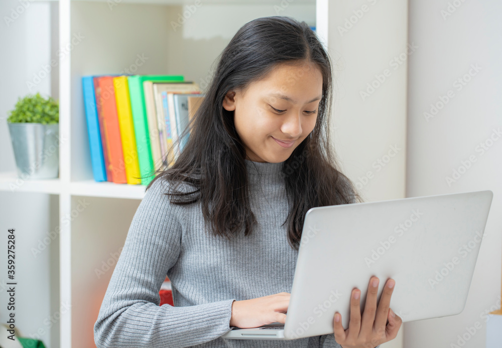 Work from home, Asian woman working with laptop computer at home office, Asia female shopping online, Happy girl learning by internet, study online education, e commerce business. Work from home, Asian woman working with laptop computer at home office, Asia female shopping online, Happy girl learning by internet, study online education, e commerce business.