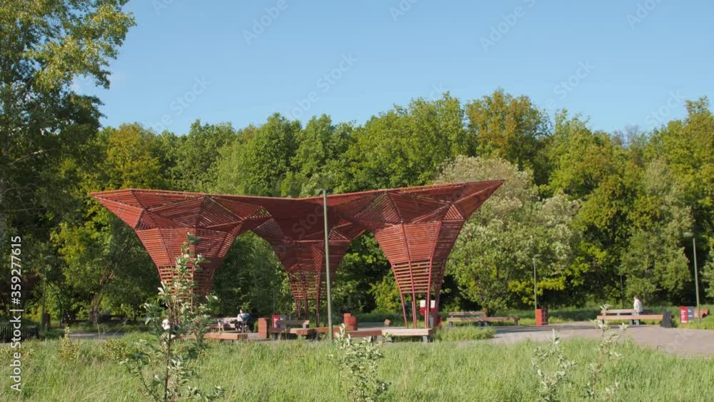 spring park with visitors resting in stylish wooden arbors spring park with visitors resting in stylish wooden arbors