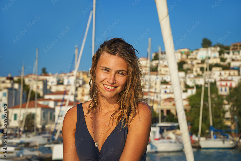 Young happy woman in sunglasses feels fun on the luxury sail boat yacht catamaran in turquoise sea in summer holidays, Greece.