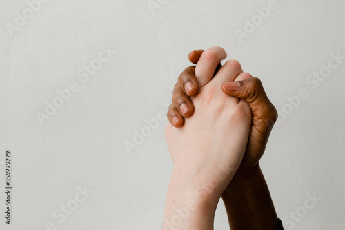 The fight against racism. Two hands of different people by skin color and nationality tightly squeeze each other