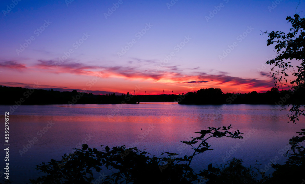 Symmetry of the sky in a lake at sunrise. Clouds reflecting on the water. 