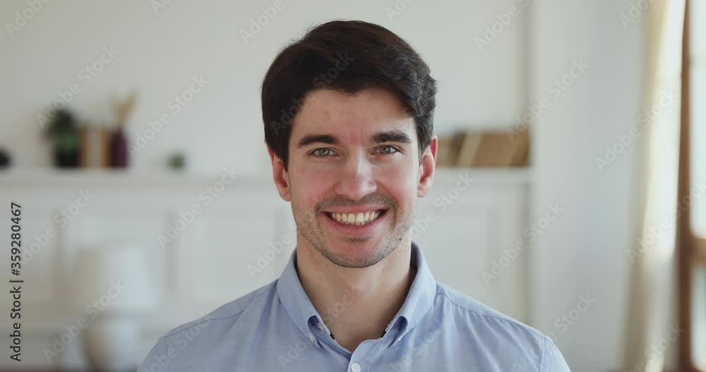 Head shot close up portrait of handsome smiling young man standing at home. Happy millennial guy client with healthy white toothy smile looking at camera, satisfied with dental care service. Head shot close up portrait of handsome smiling young man standing at home. Happy millennial guy client with healthy white toothy smile looking at camera, satisfied with dental care service.