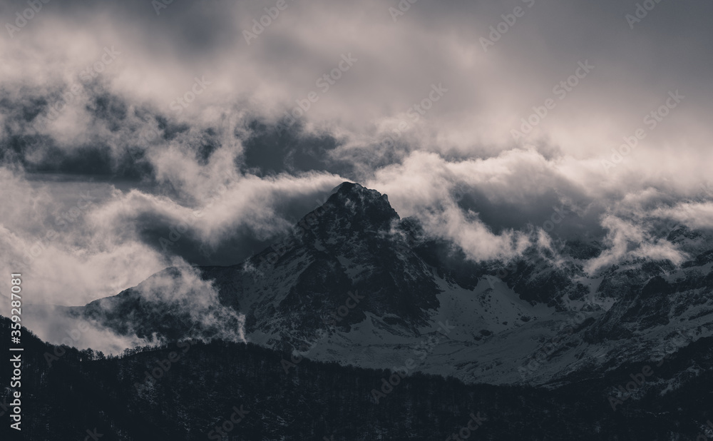 Mysterious black mountain with dramatic cloudy sky Mysterious black mountain with dramatic cloudy sky