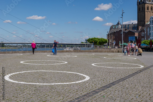 Selected focus at  group of White circles which are drawn on Burgplatz square nearby Rhine River  for concept of Social Distancing and new normal with epidemic of COVID-19 in D  sseldorf  Germany.