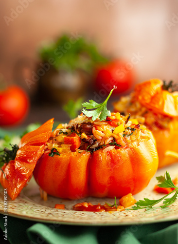 Delicious stuffed tomatoes in shape of pumpkin with rice, vegetables and meat. Concept homemade healthy eating.