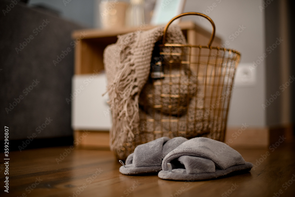Fototapeta premium view on large metal wicker basket with knitted blanket inside