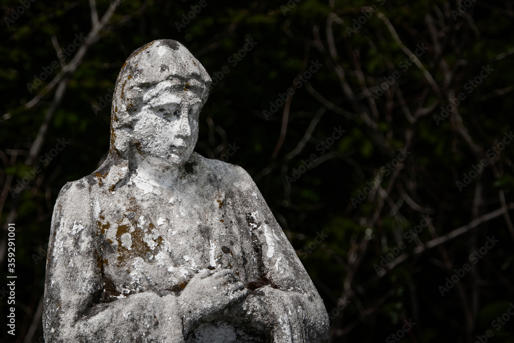 A very old sculpture of  Virgin Mary. The stone statue is partially destroyed by time.