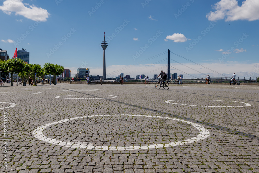 Selected focus at  group of White circles which are drawn on Burgplatz square nearby Rhine River, for concept of Social Distancing and new normal with epidemic of COVID-19 in Düsseldorf, Germany.