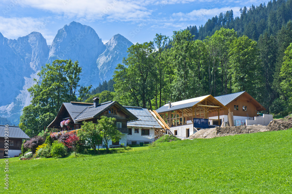 Small houses surrounded by forest and mountains in Alps, Austria, Gosau