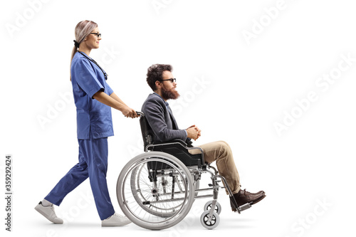 Female nurse pushing a disabled man in a wheelchair