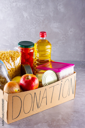 Grocery set. Donation box with food. Open cardboard box with oil, water, canned food, cereals and pasta. Donation concept