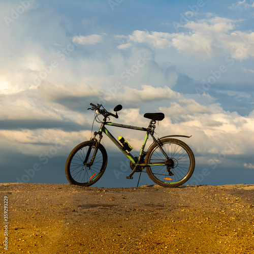 Bicycle standing on a cliff in front of the sea and sky
