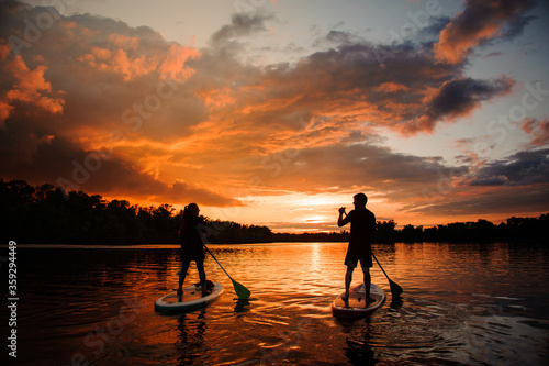 Wallpaper Mural rear view of two people on sup boards which floating on the river at sunset Torontodigital.ca
