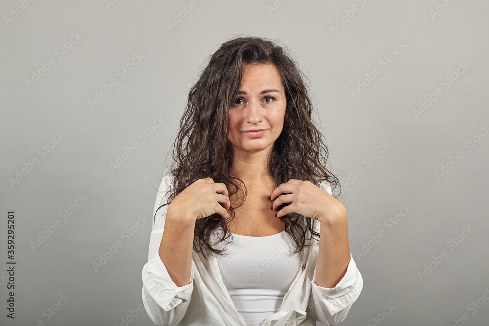 Pointing with hand at chest and staring. Shocked facial expression. Young attractive woman, dressed white blouse, with brown eyes, curly hair, yellow background Pointing with hand at chest and staring. Shocked facial expression. Young attractive woman, dressed white blouse, with brown eyes, curly hair, yellow background