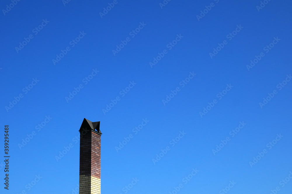 Chimney of the house against the blue sky