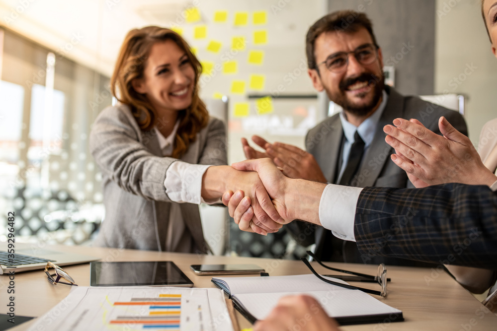 Businesswoman giving a handshake to her colleague Businesswoman giving a handshake to her colleague