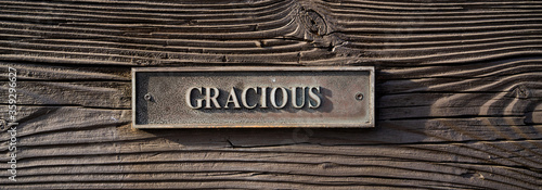 metal plaque with word gracious on wooden bench