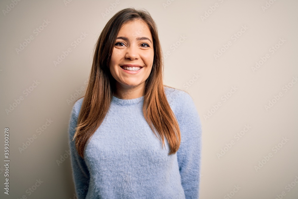 Beautiful young woman wearing casual winter sweater standing over isolated background with a happy and cool smile on face. Lucky person. Beautiful young woman wearing casual winter sweater standing over isolated background with a happy and cool smile on face. Lucky person.