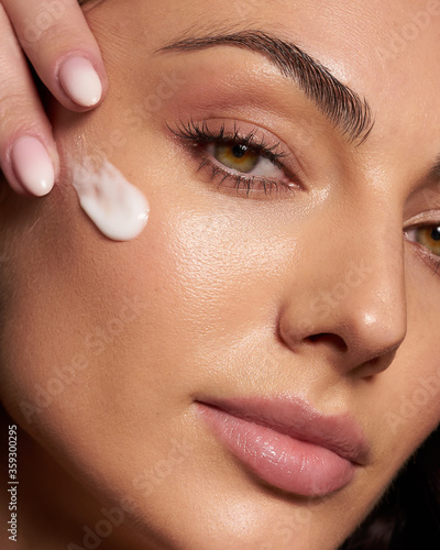 Tableau sur toile Close up beauty portrait laughing beautiful half naked woman applying face cream
