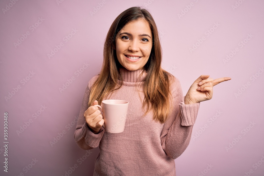 Young blonde woman drinking a cup of coffee over pink isolated background very happy pointing with hand and finger to the side Young blonde woman drinking a cup of coffee over pink isolated background very happy pointing with hand and finger to the side
