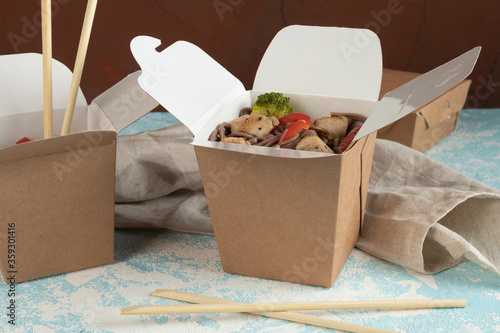 Eco packaging - noodles with vegetables, chicken and meat in craft packaging for the delivery service. Fast food.