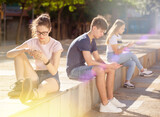 Teenagers are playing on smartphone on street