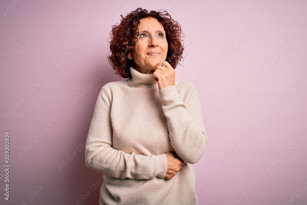 Middle age beautiful curly hair woman wearing casual turtleneck sweater over pink background with hand on chin thinking about question, pensive expression. Smiling and thoughtful face. Doubt concept. Middle age beautiful curly hair woman wearing casual turtleneck sweater over pink background with hand on chin thinking about question, pensive expression. Smiling and thoughtful face. Doubt concept.